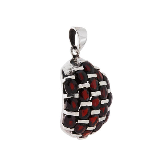 Ciondolo Etnico di forma ovale con pietre granato incastonate.